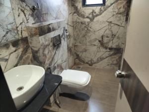 a bathroom with a sink and a toilet at Hotel Radhika in Lātūr