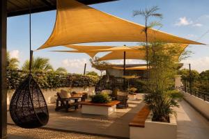 a patio with a large umbrella and chairs and plants at Casa Andrea Bukidnon in Impasugong