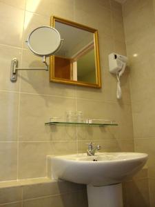 DM Hotel في كوتا كينابالو: حمام مع حوض ومرآة