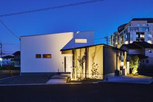 a white building in a city at night at Ｔｉｌｔ - Vacation STAY 16720 in Karatsu