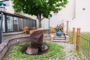 a stone statue in a garden in front of a building at Quality Inn and Conference Centre in Pembroke