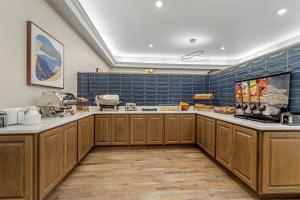a large kitchen with wooden cabinets and blue tiles at LeConte Hotel & Convention Center, an Ascend Collection Hotel in Pigeon Forge
