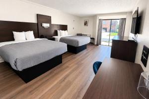 a hotel room with two beds and a television at Quality Inn Harrodsburg in Harrodsburg