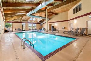 a swimming pool in a large building with wooden ceilings at Quality Inn & Suites Lawrence - University Area in Lawrence
