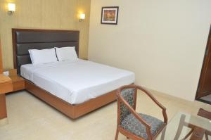 a bedroom with a bed and a chair in it at HOTEL ASHRAY INTERNATIONAL, SION - Near BKC in Mumbai