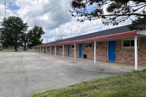 a brick building with blue doors and a parking lot at Rodeway Inn Flora in Flora