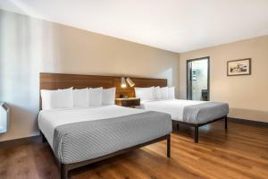 a hotel room with two beds and a window at La Luna Inn, an Ascend Collection Hotel in San Francisco