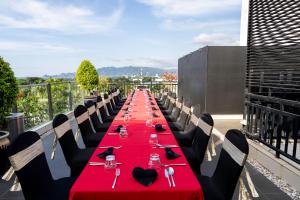 a long table with red table cloths on a balcony at Timor Plaza Hotel & Apartments in Dili