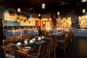 a restaurant with wooden tables and chairs and a bar at Timor Plaza Hotel & Apartments in Dili