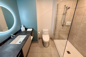 a bathroom with a shower and a toilet and a sink at Quality Inn & Suites Temiscouata-sur-le-Lac in Notre-Dame-du-Lac +5 photos