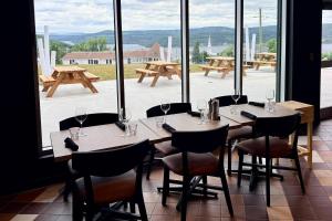 a restaurant with tables and chairs and a large window at Quality Inn & Suites Temiscouata-sur-le-Lac in Notre-Dame-du-Lac