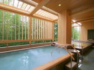 einen Pool in einer abgeschirmten Veranda mit einem großen Fenster in der Unterkunft Arima Grand Hotel in Kōbe