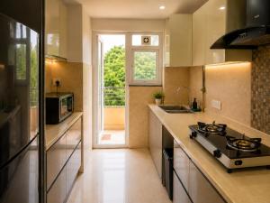 a kitchen with a stove and a sink and a window at Lime Tree Hotel Golf Course Extension Nearby Grand Hyatt Gurgaon in Gurgaon