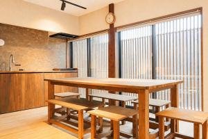 a kitchen with a large wooden table and benches at ceueu 櫟本駅 in Tenri