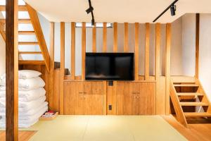 a living room with a television and a staircase at ceueu 櫟本駅 in Tenri