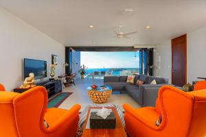 a living room with orange chairs and a couch at The heights luxury sea view 2BR near Kata Beach in Kata Beach