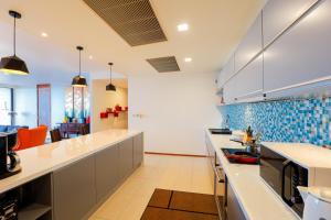 a large kitchen with white counters and blue tiles at The heights luxury sea view 2BR near Kata Beach in Kata Beach