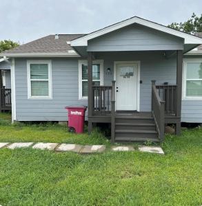 a house with a front porch and a trash can at Only minutes away from Surfside Beach in Freeport