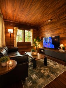 a living room with a couch and a flat screen tv at Hidden Home Samui in Koh Samui