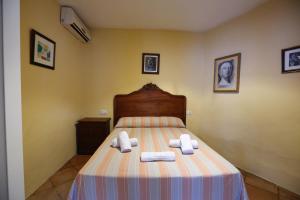 a bedroom with a bed with towels on it at El Rincón de San Benito in Cazalla de la Sierra