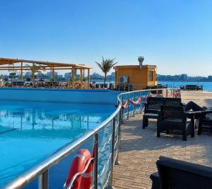 a person sitting on a bench next to a swimming pool at darnas in Jeddah +8 photos