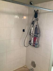 a bathroom with a white tiled wall with a shower at Cozy nest in Coquitlam