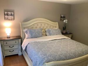 a bedroom with a bed and a night stand with a lamp at Cozy nest in Coquitlam