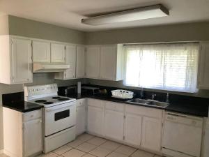 a kitchen with white cabinets and a white stove top oven at Cozy nest in Coquitlam