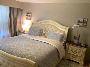 a bedroom with a large bed with two pillows at Cozy nest in Coquitlam +8 photos