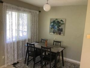 a dining room with a table and chairs and a window at Cozy nest in Coquitlam