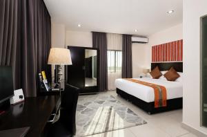 a hotel room with a bed and a desk and a desk at Timor Plaza Hotel & Apartments in Dili