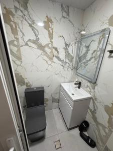 ein Badezimmer mit Waschbecken und Marmorwand in der Unterkunft Ruma Hotel in Yerevan
