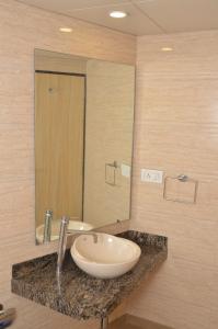a bathroom with a sink and a large mirror at HOTEL ASHRAY INTERNATIONAL, SION - Near BKC in Mumbai +35 photos