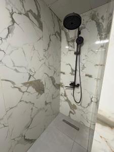 eine Dusche in einem Badezimmer mit Marmorwand in der Unterkunft Ruma Hotel in Yerevan