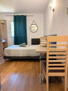 a bedroom with a bed and a table with a dining room at Le Clos d'AIX studio 305 in Aix-en-Provence