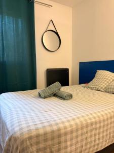 a bed with a hat and a mirror on it at Le Clos d'AIX studio 305 in Aix-en-Provence