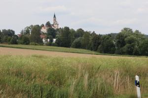 a field of grass with a building in the background at Ferienoase übern Zottbachtal in Pleystein