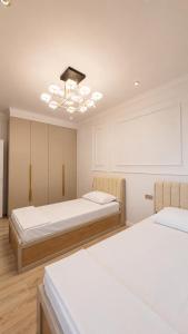 a room with two beds and a chandelier at High Town City in Lunacharskiy Bekati