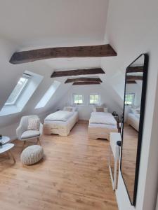 a attic room with two beds and a mirror at Lichtdurchflutete Dachgeschosswohnung mit Charme in Goldenstedt