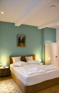 a large bed in a room with blue walls at Sándor János Villa in Sovata
