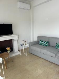 a living room with a couch and a fireplace at Anna Coast Apartment in Agia Anna