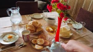 a table with a breakfast of eggs and bread at Ushba Hearth House in Tvebishi +13 photos