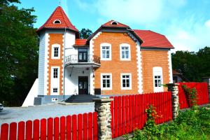 a brick house with a red fence in front of it at Sándor János Villa in Sovata