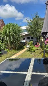 two pictures of a yard with a house and a pond at NEU! Dat Lütt Hüs in Tönning