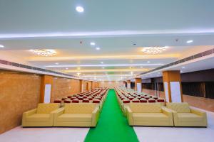 a large room with chairs and a green carpet at Hotel RAAGA INN in Tirupati