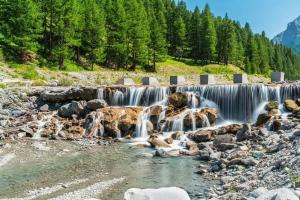 a group of waterfalls in a river with trees at Rifugio del Piemont in Villaretto +8 photos