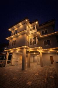 a large white building with lights on it at night at Dreams Arcade in Nedumbassery