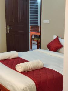 a bed with two towels on top of it at Dreams Arcade in Nedumbassery