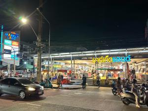 a busy city street at night with cars and people at Nopphadon Hotel in Lat Krabang