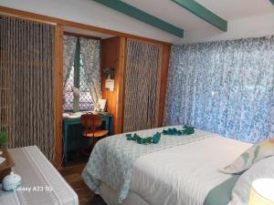 a bedroom with two beds and a desk and a window at Alba the Scots Cottage walk every where in Maleny